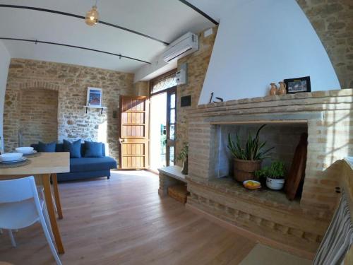 a living room with a blue couch and a brick fireplace at “La Casetta del 1930” Historic unit from early '900 in Ortona
