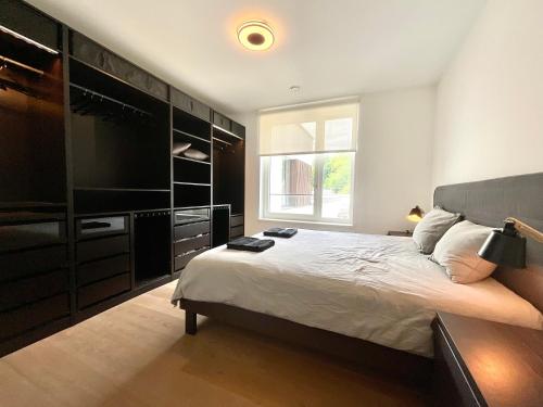 1 dormitorio con 1 cama grande y TV en Kirchberg Apartment - High End 2 Bedrooms in Luxembourg City, en Luxemburgo
