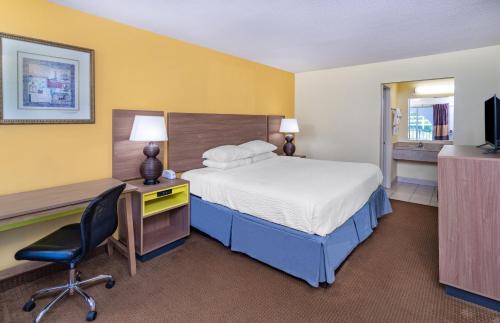 a hotel room with a bed and a desk at Days Inn by Wyndham Owensboro in Owensboro