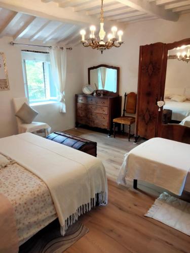 1 dormitorio con 2 camas y espejo en Il giardino dei sogni, en Montefortino