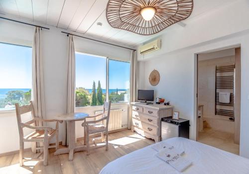 a bedroom with a bed and a desk and a window at Villa Paradis in Les Issambres