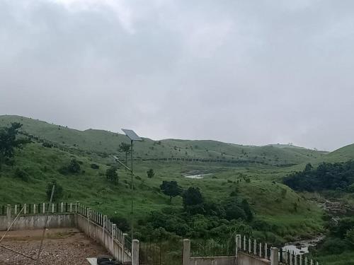 a view of a green hill with a fence at Sulawado Resort in Cherrapunji
