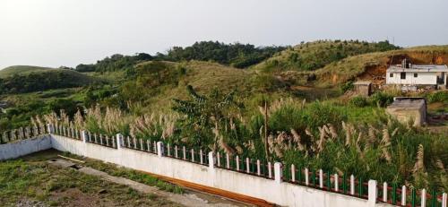 a white fence on top of a hill at Sulawado Resort in Cherrapunji
