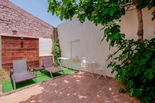 a patio with two chairs and a table in a yard at Il Monastero in Geremèas