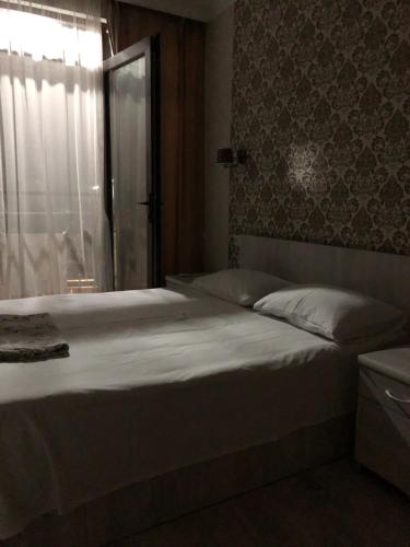 a bedroom with a large white bed with a window at PAPILLON in Chakvi