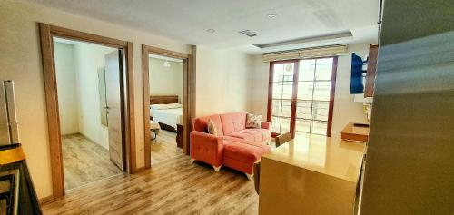 a living room with a red chair and a bedroom at İnce Apart Rezidence in Trabzon