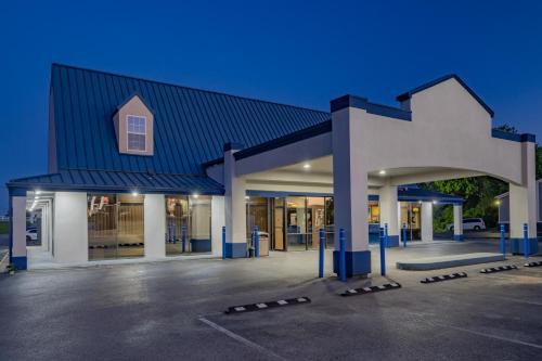 a building with a blue roof and a parking lot at Rodeway Inn in Owensboro