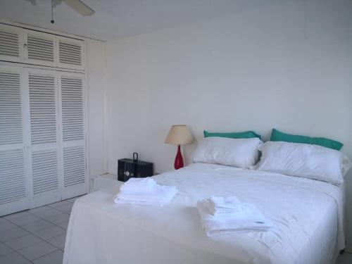 a bedroom with a white bed with towels on it at Stunning views at sky castles Ocho Rios in Eden Bowers