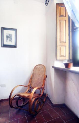 a rocking chair in a room with a window at Casa Vacanze Antico Poggio in Poggio San Giovanni