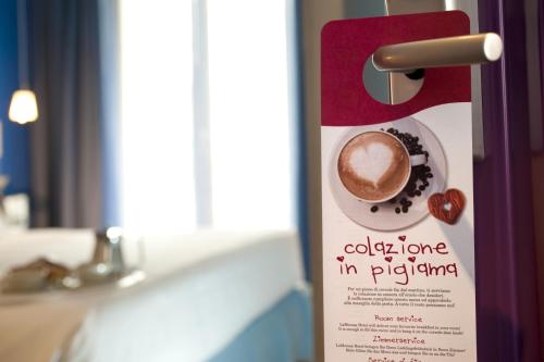 a sign on a door with a cup of coffee at Hotel LaMorosa in Rimini