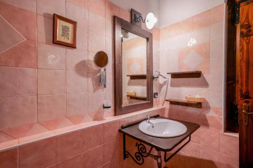 a pink bathroom with a sink and a mirror at Il Monastero in Geremèas