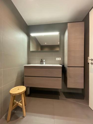 ein Badezimmer mit einem Waschbecken und einem Holzhocker in der Unterkunft Kirchberg Apartment - High End 2 Bedrooms in Luxembourg City in Luxemburg (Stadt)