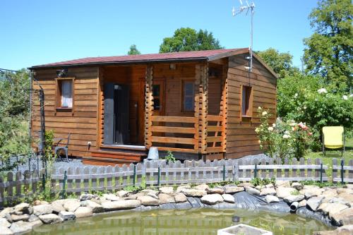 a log cabin with a pond in front of it at Le Jardin des Pierres Brunes in Saint-Jean-des-Ollières