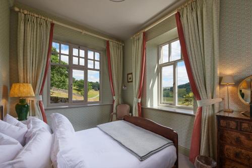 1 dormitorio con 2 camas y 2 ventanas en Devonshire Arms Holiday Cottages at Bolton Abbey, en Bolton Abbey