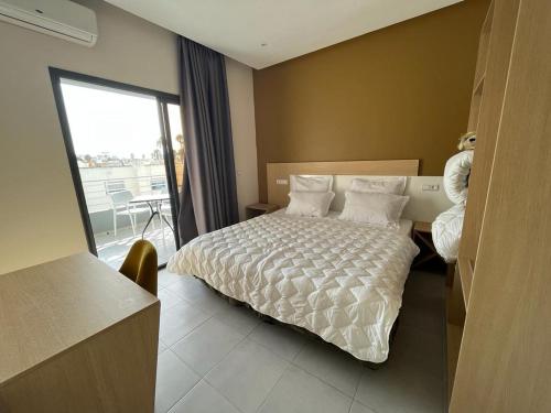 a hotel room with a bed and a balcony at Appart Hôtel Pyramides El Jadida in El Jadida