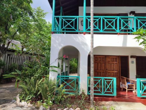 a house with a blue door and a balcony at Ltu Garden in Negril