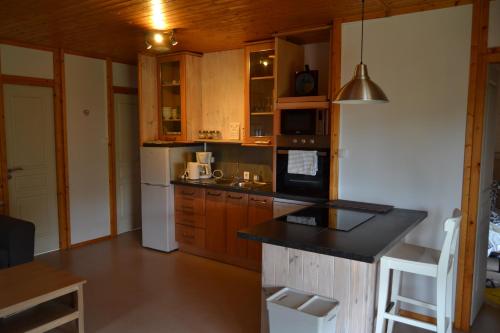 a kitchen with wooden cabinets and a white refrigerator at Beautiful lake view 3 bedroom chalet. in Saint-Manvieu-Bocage