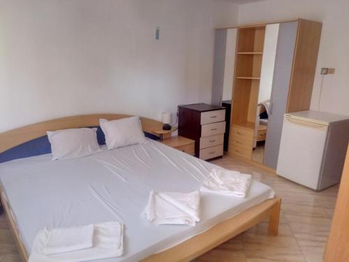 1 dormitorio con 1 cama con sábanas blancas y vestidor en Farlalievi Guest House en Sozopol