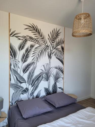 sypialnia z malowidłem palmowym na ścianie w obiekcie Le Stepharion w mieście La Gaubretière