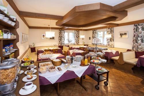 ein Restaurant mit Tischen und Stühlen mit Essen darauf in der Unterkunft Gästehaus Sunkler in Golling an der Salzach
