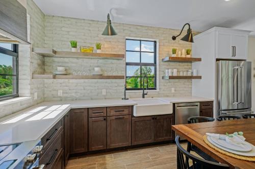 Una cocina con gabinetes de madera y un fregadero y una mesa. en Point of Rocks, en Sarasota