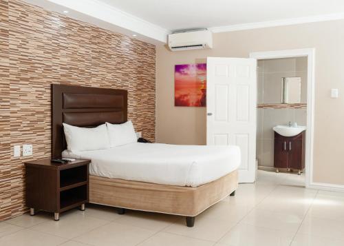 a bedroom with a large bed and a sink at Bayside Hotel 100 Pixley Kaseme Street (West Street) in Durban
