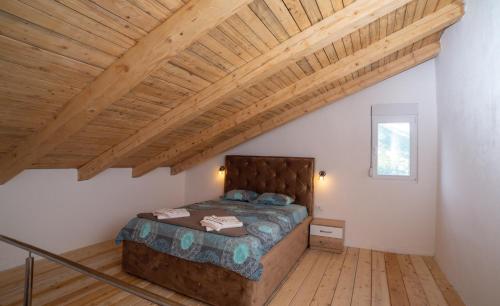 1 dormitorio con cama y techo de madera en Brioni, en Virpazar