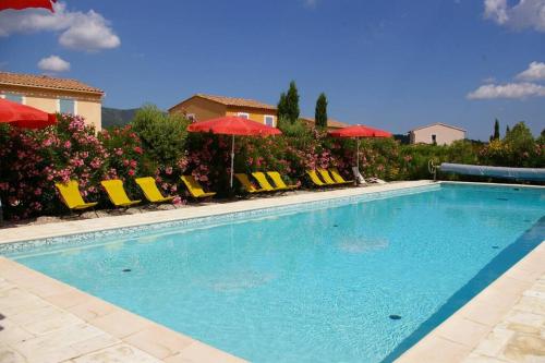 a large swimming pool with chairs and umbrellas at Beautiful holiday villa in Provence France in Aups