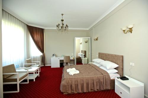 a bedroom with a bed and a desk and a chair at Miraj hotel in Baku