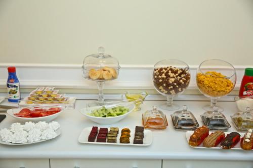 eine weiße Theke mit Schalen und Teller mit Lebensmitteln in der Unterkunft Miraj hotel in Baku
