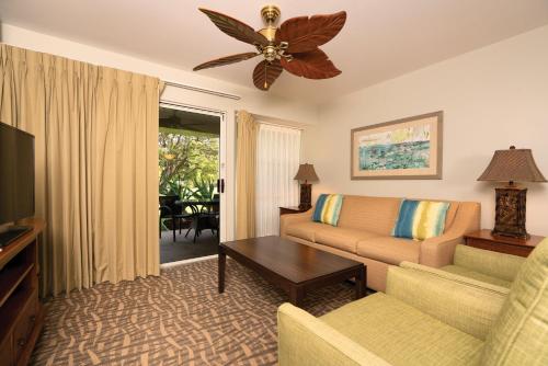 sala de estar con sofá y TV en Paniolo Greens Resort en Waikoloa