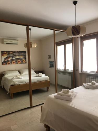 a bedroom with two beds and a large mirror at La torre in Velletri