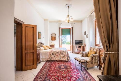 um quarto com uma cama, uma cadeira e um tapete em Villa in Pineta em Sinalunga