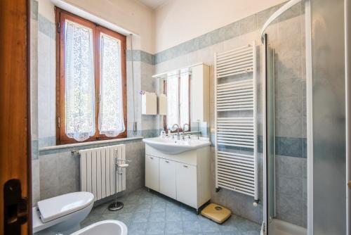 a bathroom with a sink and a toilet and a shower at Villa in Pineta in Sinalunga