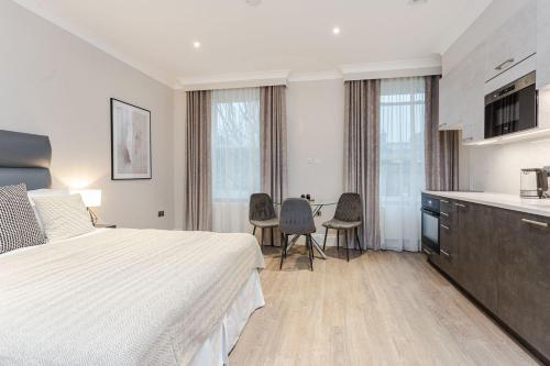 Habitación de hotel con cama y cocina en Cleveland Residences Chelsea, en Londres