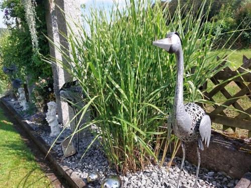 a statue of a bird standing in a garden at Ferienwohnung Gaul in Riedenburg