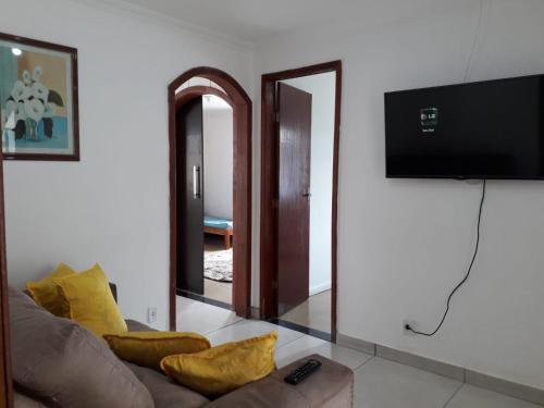 a living room with a couch and a flat screen tv at Casa Super CONFORTÁVEL a 8min da praia do Forte in Cabo Frio