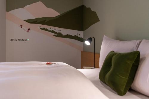a bedroom with a bed with a mountain mural on the wall at Hotel Schweizerhof Lenzerheide in Lenzerheide