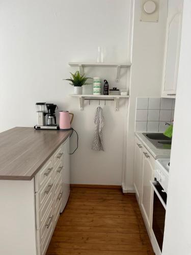 圖爾庫的住宿－Lämminhenkinen yksiö Port Arthurissa，厨房铺有木地板,配有白色橱柜。