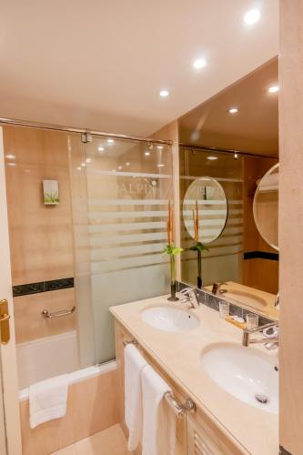 a bathroom with two sinks and a shower at Guadalpin Suites in Marbella