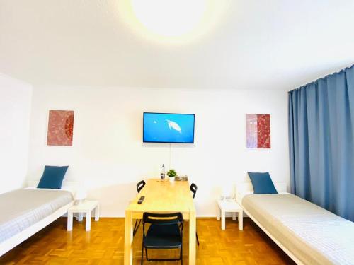 a room with two beds and a table with a desk at HannoverMesseApartment 2 bedroom in Hannover