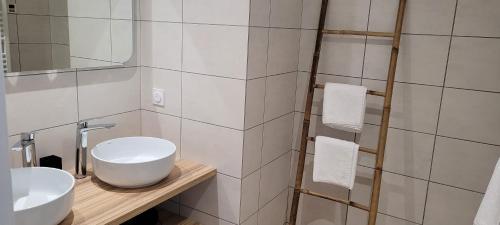 a bathroom with two sinks and a mirror at Ferme Peyroutet in Asson