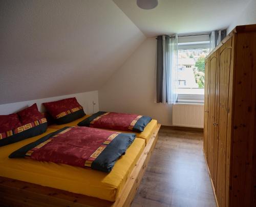 1 dormitorio con 2 camas y ventana en Ferienhaus Schulte - Villa Jupp und Apartment Liesl, en Olsberg