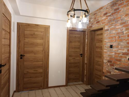 a hallway with wooden doors and a brick wall at Ojców, Na Widoku in Ojców