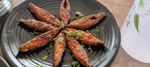 a gray plate with some fried food on it at Redstone House by Oxystays Hospitality in Ganpatipule