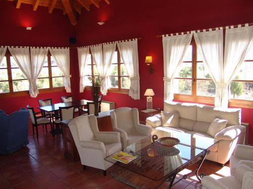 a living room with white chairs and tables and windows at Hotel & SPA Peña Montañesa in Aínsa