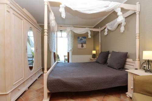 un dormitorio con una cama con dosel en Fewos Herrmann Achterwasserblick, en Loddin