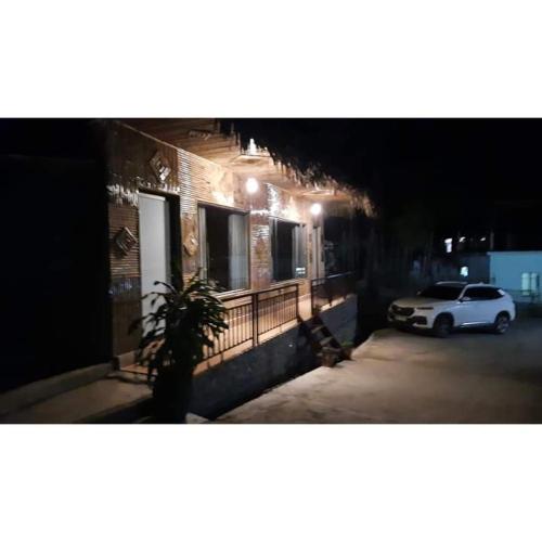 a white car parked next to a building at night at Thao Ly Homestay Mai Chau in Hòa Bình