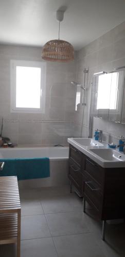 ein Badezimmer mit einer Badewanne, einem Waschbecken und einer Badewanne in der Unterkunft Chez Valérie in Vergèze