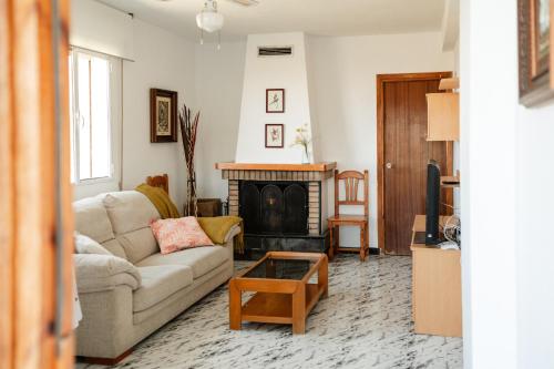 sala de estar con sofá y chimenea en Casa rural Balcón de Monachil, en Monachil